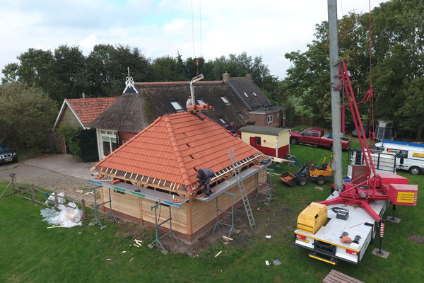 Houten landelijke schuur met schild dak aan huis 